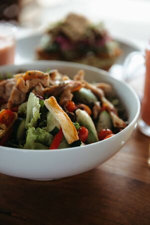 Salad with chicken, cucumbers, tomatoes, peppers, lettuceの写真素材