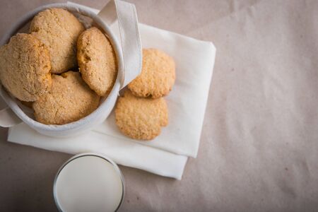 homemade biscuits in a linen basket on a beige background. cracked cookies. Healthy sweets cooking...