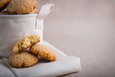 homemade biscuits in a linen basket on a beige background. cracked cookies. Healthy sweets cooking for family.の写真素材