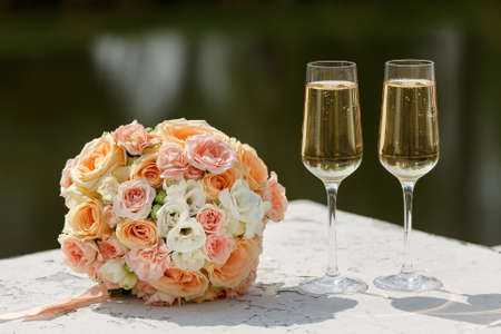 two glasses of sparkling wine and bouquet of the bride.の写真素材