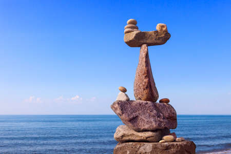 Concept of harmony and balance. Balance and poise stones against the sea. Rock zen in the form of scalesの写真素材