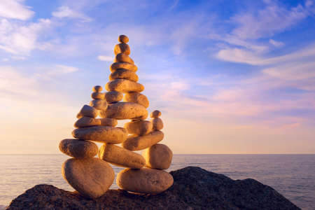 Concept of harmony and balance. Rock Zen at sunset. Balance and poise stones against the seaの写真素材