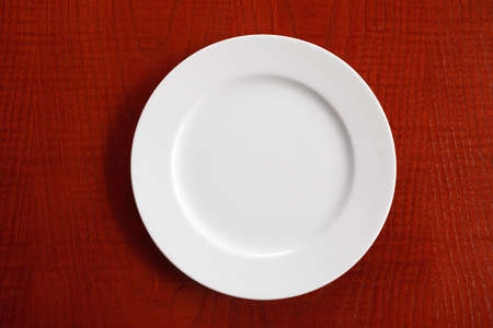 empty, clean, white plate on wooden table