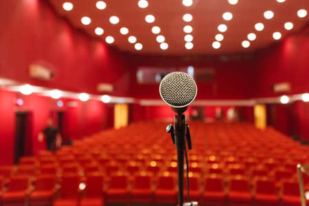 microphone on a background of red hall with seating for spectators. chairs for the audienceの写真素材