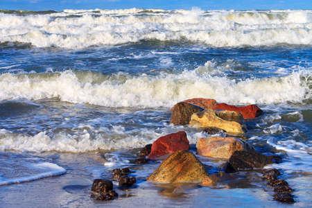 beautiful storm at sea, breakwaters and rocks in the foregroundの写真素材