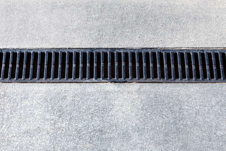 Modern drainage system. The drain on the road or the sidewalkの写真素材