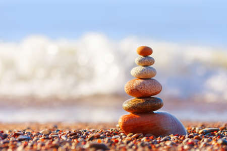 Pyramid of colorful, balanced stones on the sea background. Concept of harmony and balance. Soft focus, selective focusの写真素材
