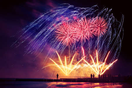 Beautiful, festive, colorful fireworks over the sea with reflection. Very long shutter speedの写真素材