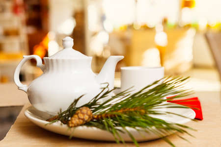 White ceramic teapot and Cup for tea, a sprig of pine in the foreground. Soft focus, selective focus. morning moodの写真素材