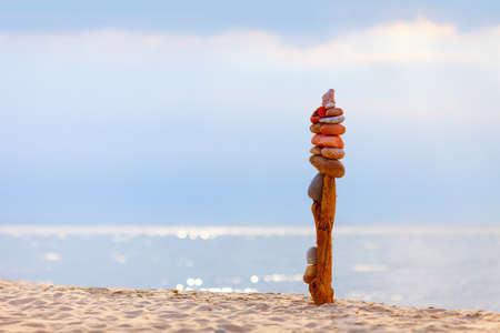 High Rock zen pyramid of stones in the rays of the setting sun against the sea Concept of balance, harmony and meditationの写真素材