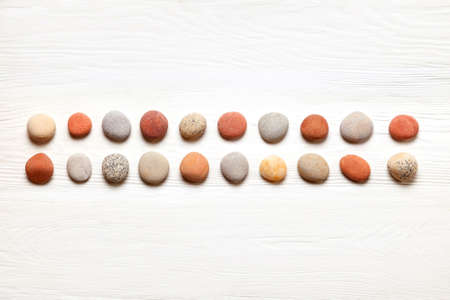 pattern of colored pebbles on white wooden background. Meditation and calmness concept. Flat lay, top view. copy spaceの写真素材