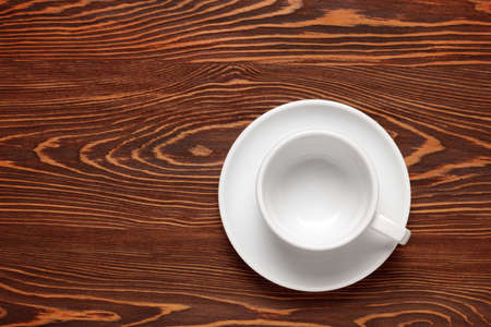 White, clean, empty Cup on a dark wooden background. Top view. Copy spaceの写真素材