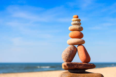 Rock zen pyramid of white and pink pebbles on the beach. Concept of balance, harmony and meditation