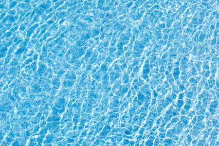 The movement of water in the blue pool with sun glare. Background image