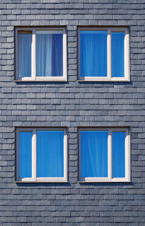 wall of the house is decorated with tiles of black Silesian slate and four Windowsの写真素材