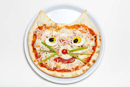 Children's pizza in the shape of a cat's face on a white plate, on a white background, top view. Children's menuの写真素材