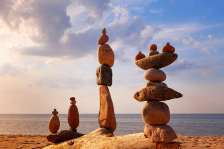 Several Rock zen pyramids of colorful pebbles standing on the beach, on the background of the sea. Concept of balance, harmony and meditationの写真素材