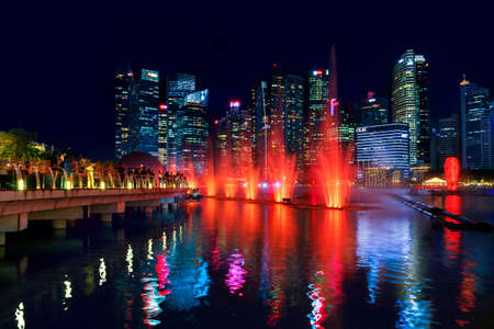 SINGAPORE-November 29, 2019: Night show of fountains in Singapore near the Marina Bay Sands hotel against the skyscrapers of the business centerのeditorial素材