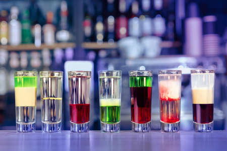Set of different alcoholic shots cocktails served on bar counter. Soft focus, selective focus
