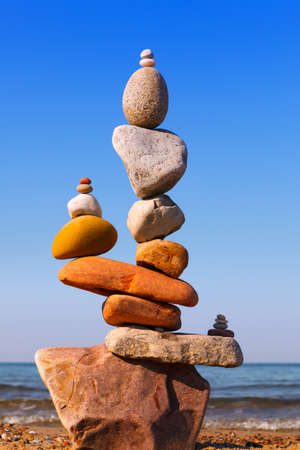 Rock zen Pyramid of balanced stones against the background of the sea and blue sky. Concept of balance, harmony and meditationの素材 [FY310158701479]