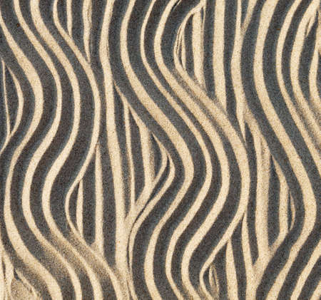 The pattern on the yellow sand made by the fingers of the hands. Top view