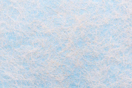 The surface is made of white fibers similar to a frosty pattern on a blue background. Christmas backdrop, copy spaceの写真素材