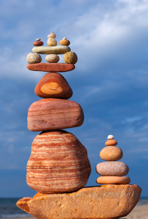 A high pyramid of stones against a cloudy sky. The concept of life balance, harmony and meditationの写真素材