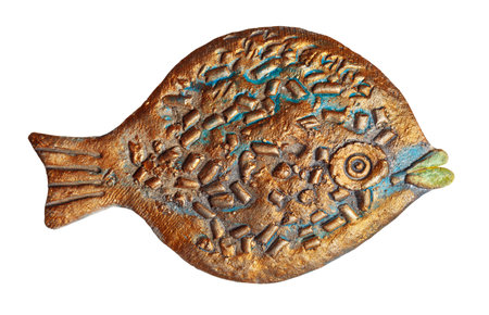 Flat ceramic fish with a textured surface, painted with blue and gold paint. Isolated on a white...