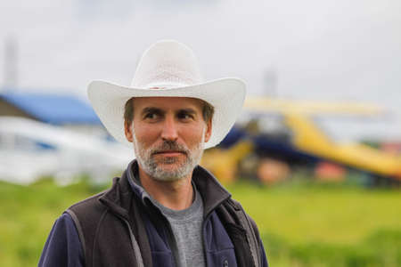 Portrait of a man with gray beard in white hat