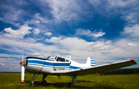 Propeller plane on the aerodrome on cloudy sky background