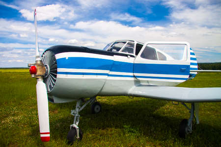 Propeller plane on the aerodrome on cloudy sky background
