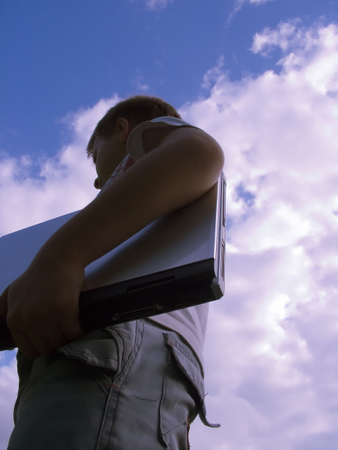 The child with a portable computer in the blue sky.の写真素材