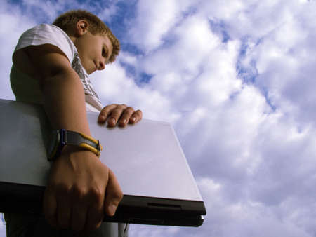 The child with a portable computer in the blue sky.の写真素材