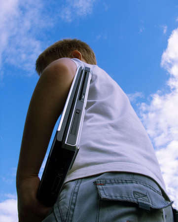 The child with a portable computer in the blue sky.の写真素材