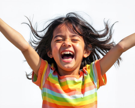 A joyful young girl with dark hair and vibrant striped shirt, beaming with a wide smile and raised arms, exuding carefree happiness.の素材