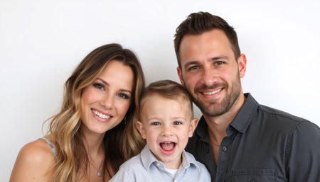 A joyful family portrait featuring a smiling couple with their excited child.の素材