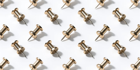 A repeating pattern of gold-colored push pins with threaded shafts and sharp points on a white background.の素材