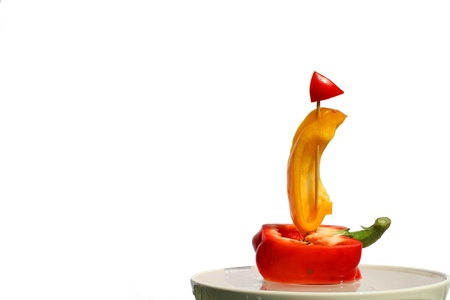 of red and yellow peppers made sailboat, sailing on the waterの写真素材