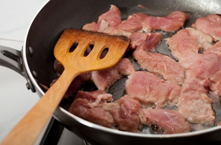 cooking meat in a frying panの写真素材
