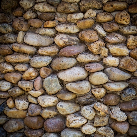 background made of a closeup of a wall with pebbles の写真素材