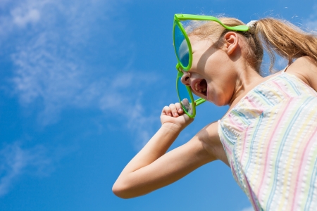 girl in big sunglasses looking at the skyの写真素材