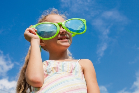 girl in big sunglasses looking at the skyの写真素材