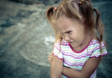 Sad little girl near the road の写真素材