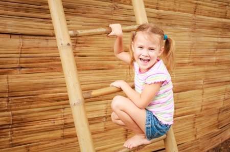 the girl  on the playground on the bamboo ladderの写真素材