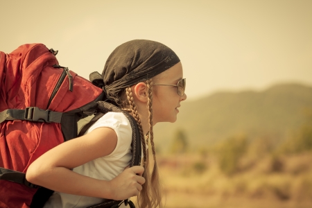 little girl with backpack walking on the roadの写真素材