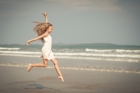 flying jump beach girl on blue sea shore in summer vacationの写真素材
