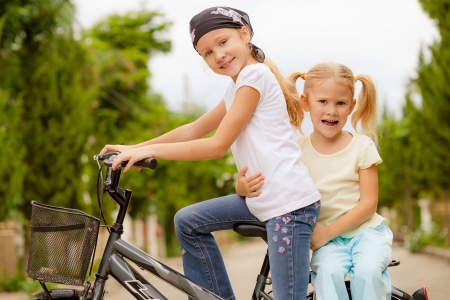 two happy children on a bicycleの写真素材