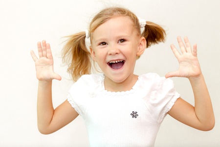 Cheerful smiling little girl at the white background  School conceptの写真素材