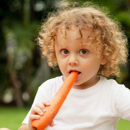 Happy little boy holding a carrots  Concept of healthy food  の写真素材