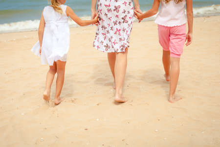 Happy family playing at the beach in the day timeの写真素材